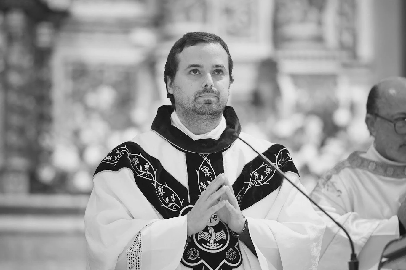 Padre em momento de oracao durante uma cerimonia